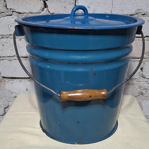 Puede incluir: Una taza de cerámica blanca con un asa negra y el texto "But First, Coffee" en negro, con una fuente de estilo manuscrito. La taza está sobre una superficie blanca.