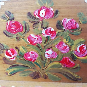 May include: Hand-painted wooden box with a floral design. The box features a bouquet of pink and white roses with green leaves on a light brown background.