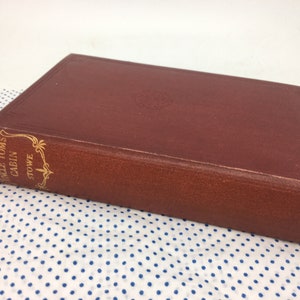 K&ouml;nnte beinhalten: Ein rotes Hardcover-Buch mit goldenen Lettern auf dem R&uuml;cken. Der Titel lautet "Onkel Toms H&uuml;tte" von Harriet Beecher Stowe.
