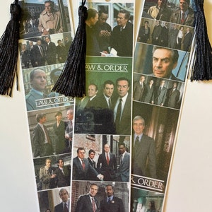 May include: Three bookmarks featuring images of the cast of the TV show "Law & Order". Each bookmark has a black tassel.