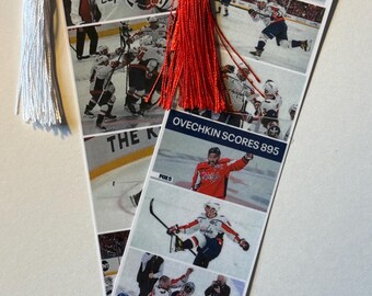 May include: Two white bookmarks with images of a hockey player, one with a white tassel and the other with a red tassel. The text "OVECHKIN SCORES 895" is visible on one bookmark. The bookmarks feature action shots of hockey games.