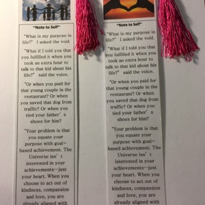 May include: Two pink bookmarks with inspirational quotes about finding your purpose in life. The quotes are printed on white paper with black text. The bookmarks feature images of hands forming a heart shape with a sunset in the background.