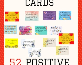 May include: A set of 52 positive affirmation cards with various affirmations in a bold, black font. The cards are on a red and white striped background. Each card has a unique design and message.