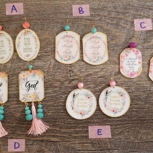 May include: Assortment of floral and scripture themed earrings.  The earrings are made of wood and feature a variety of colors, including pink, blue, and green.  The earrings are decorated with flowers, leaves, and scripture verses.  The earrings are sold in pairs.