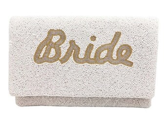 May include: White beaded clutch with the word "Bride" in gold lettering.