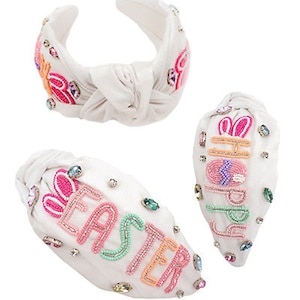 May include: White headband with a knotted design and colorful embroidered Easter bunny and text "Happy Easter".