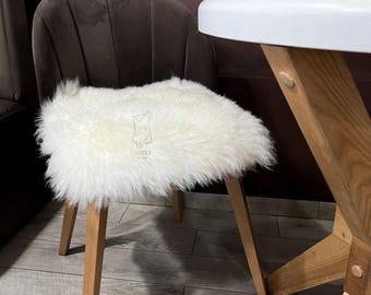 May include: A white faux fur chair cushion with a brown velvet chair and a white table with wooden legs.