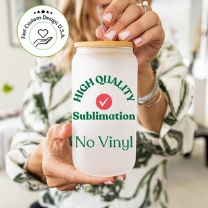 Pu&ograve; includere: Un bicchiere bianco con un coperchio in bamb&ugrave; e un design verde e bianco che dice "Alta Qualit&agrave; Sublimazione Senza Vinile".
