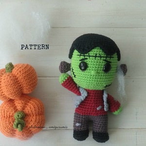 Puede incluir: Muñeco de Frankenstein tejido a mano con un rostro verde, cabello negro y una camisa roja. Junto a él hay una calabaza de ganchillo naranja. La palabra "PATTERN" está impresa encima de la calabaza.