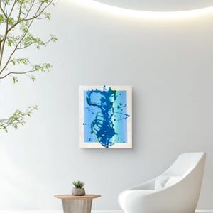 May include: A rectangular wall art piece featuring a light blue background with vertical stripes and a central abstract design composed of dark blue and green paint splatters, drips, and fluid, organic shapes across the canvas surface.