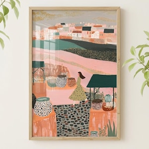 May include: A framed art print depicting a village scene with a woman in a green dress. The artwork features a color palette of pink, green, and brown, with decorative pots and a well. The frame is made of light-colored wood.