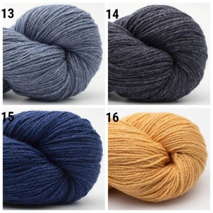 May include: Four skeins of yarn in different colors: light blue, dark gray, navy blue, and yellow. The yarn is arranged in a square with each skein in a separate quadrant. The numbers 13, 14, 15, and 16 are printed in the top left corner of each quadrant.