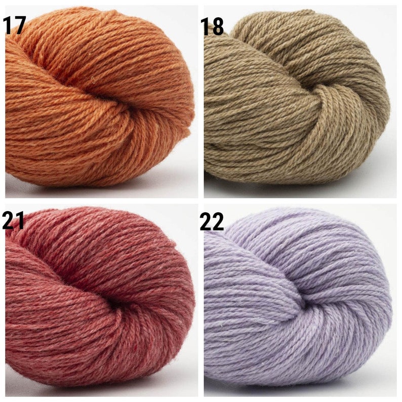 May include: Four skeins of yarn in different colors: orange, brown, red, and purple. The yarn is wound into balls and is ready to be used for knitting or crocheting.