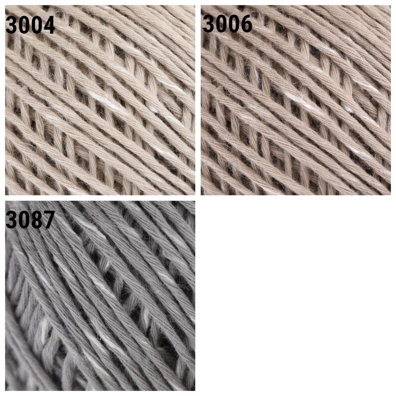 May include: Close-up of three skeins of yarn in beige and gray colors. The yarn is made of cotton and has a textured surface. The skeins are labeled with the numbers 3004, 3006, and 3087.