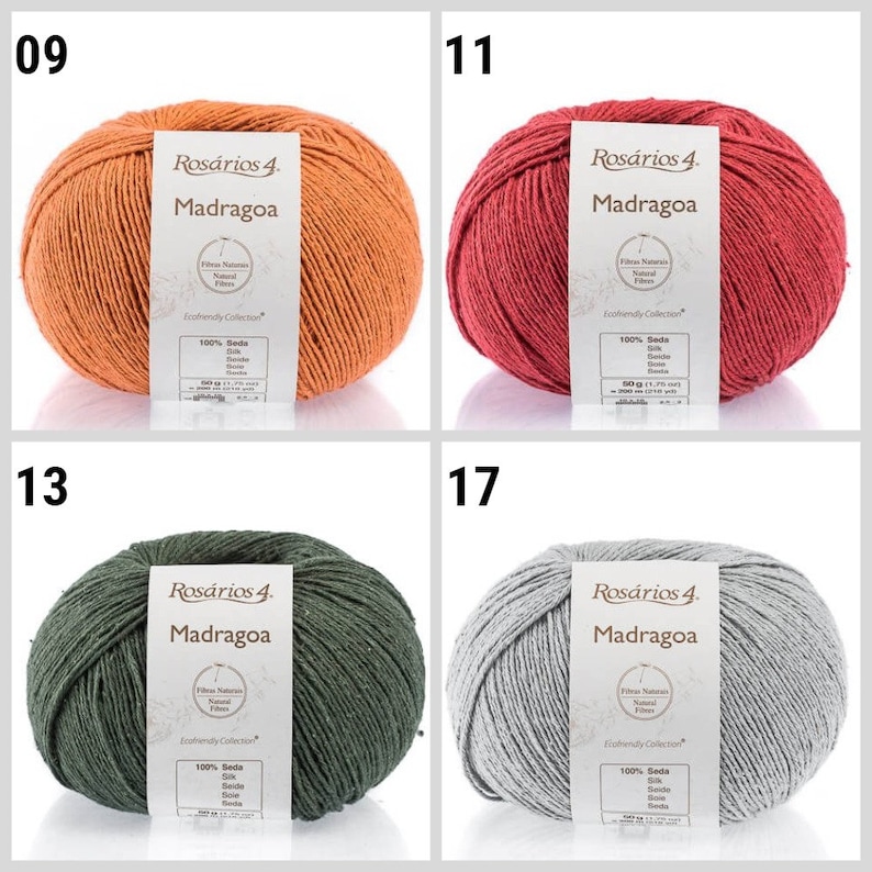 May include: Four skeins of yarn in different colors: orange, red, green, and gray. Each skein has a label that reads "Ros&aacute;rios 4. Madragoa" and includes information about the yarn's composition and origin.