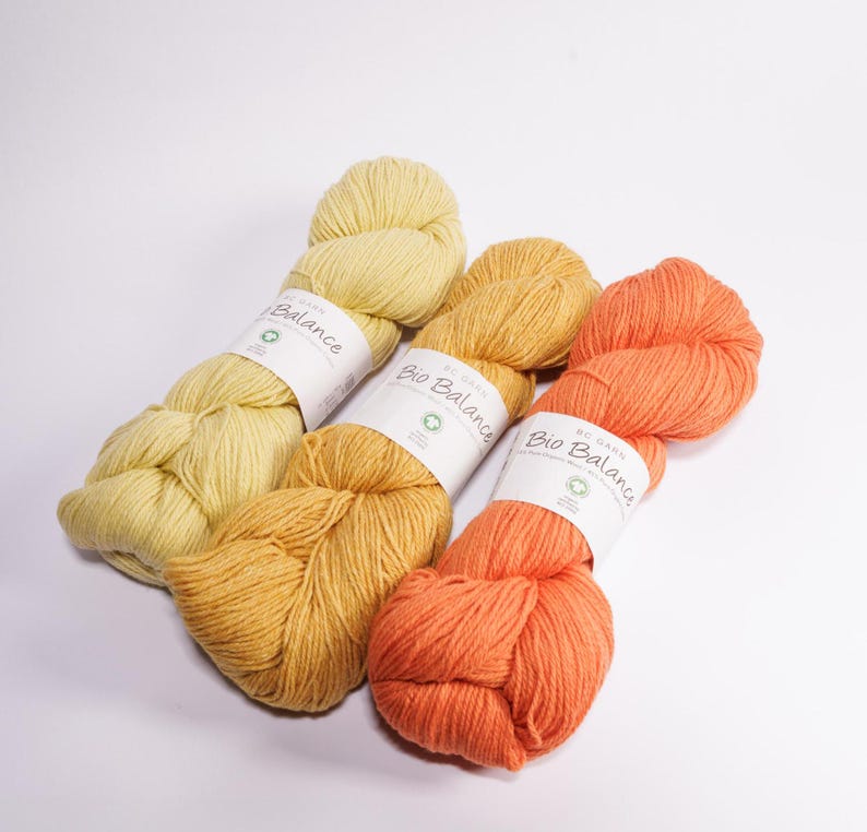 May include: Three skeins of yarn in shades of yellow and orange. The yarn is labeled "Bio Balance Organic Cotton."
