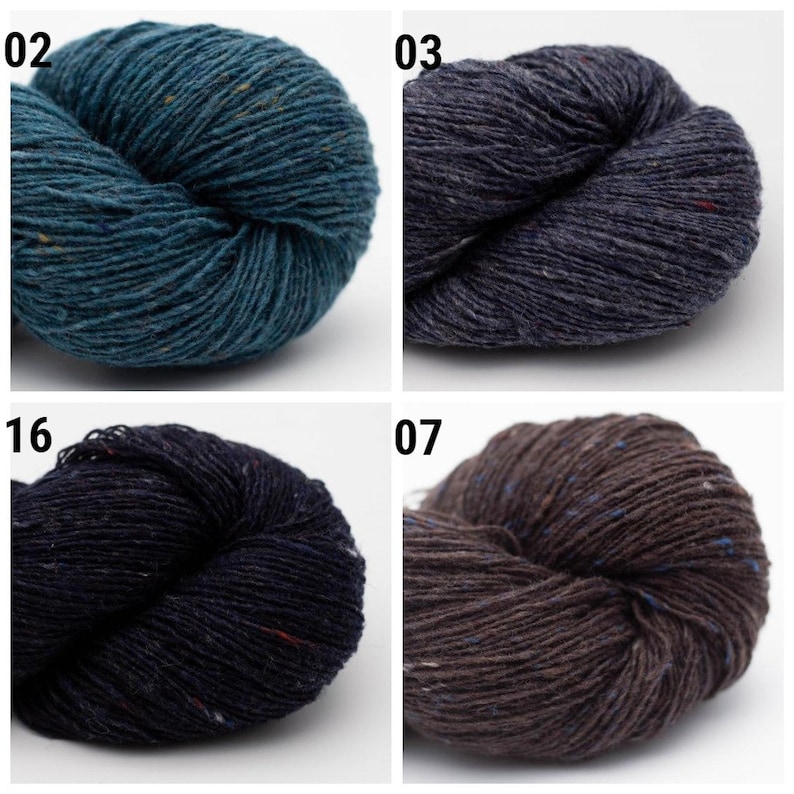 May include: Four skeins of yarn in different colors: teal, dark blue, navy blue, and brown. Each skein has a speckled pattern.