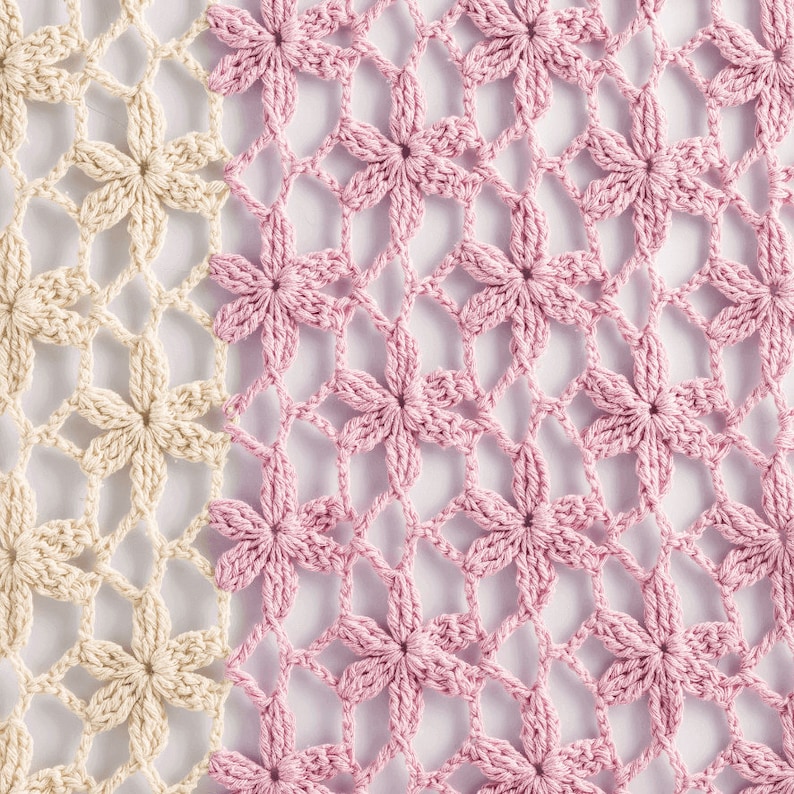 May include: A close-up of a crocheted fabric with a pattern of flowers. The fabric is half beige and half pink.