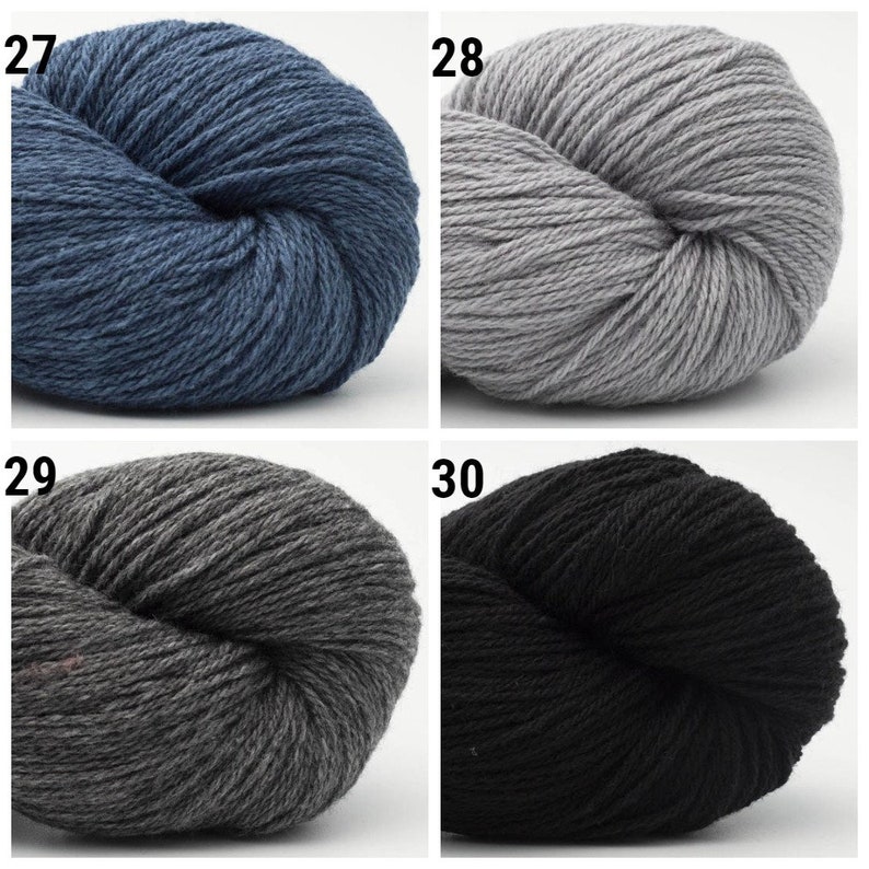 May include: Four skeins of yarn in different colors: blue, gray, dark gray, and black. The yarn is arranged in a grid pattern with the numbers 27, 28, 29, and 30 printed above each skein.