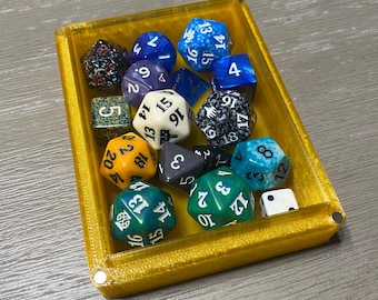 Puede incluir: Una bandeja amarilla llena de dados de colores con números en ellos. Los dados son de varios colores, incluyendo azul, verde, rojo y blanco.
