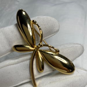 Beautiful gold tone dragonfly brooch with mirror finish.  Excellent quality.  Great condition. 2 inches wide x 1.25 inches tall.