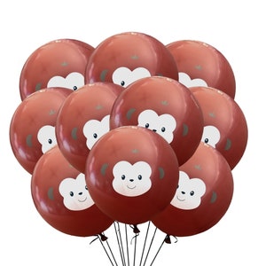 May include: A bunch of red balloons with a monkey face design. The balloons are tied together with black strings.