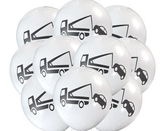 May include: A bunch of white balloons with black tow truck and car graphics. The tow trucks are all facing the same direction and the cars are all facing the opposite direction.