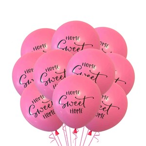 May include: A group of pink balloons with the text "Home Sweet Home" printed on them.