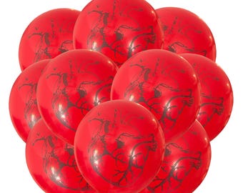 May include: A cluster of red balloons, each printed with a black anatomical heart design. The balloons are arranged closely together, creating a dense visual display. The balloons are tied together with pink ribbons.