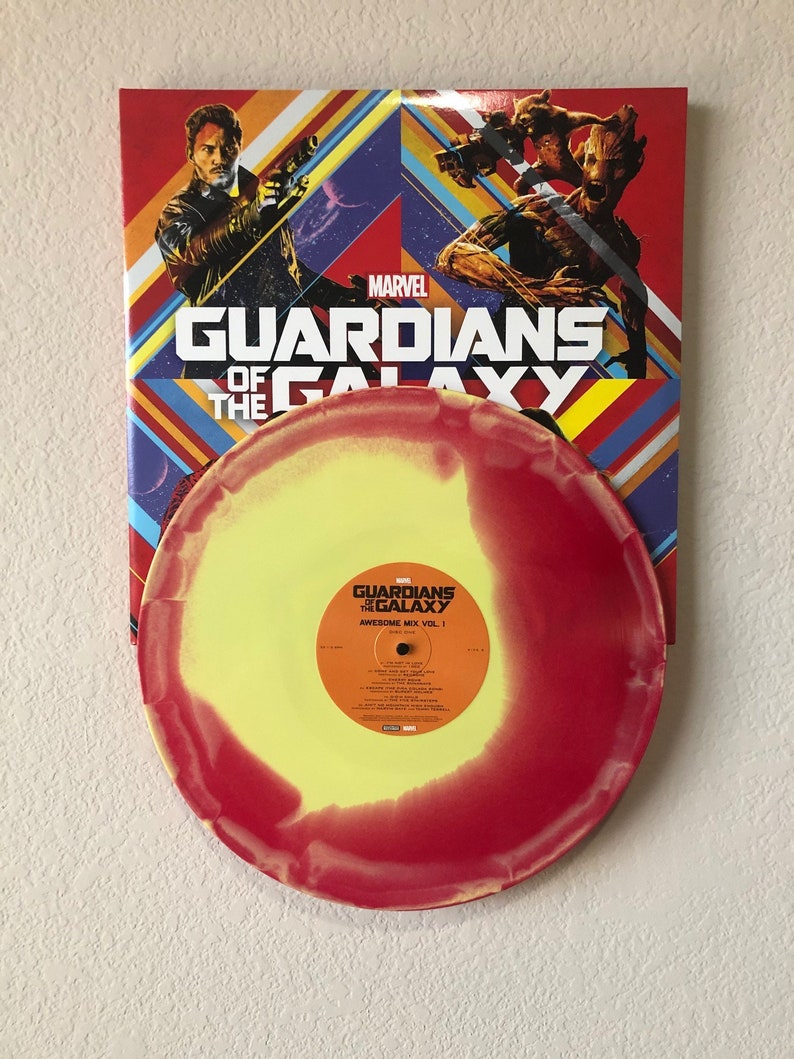 May include: A vinyl record from the Guardians of the Galaxy Awesome Mix Vol. 1 soundtrack. The record is yellow and red, with the album title and tracklist visible. The album cover features characters from the movie.