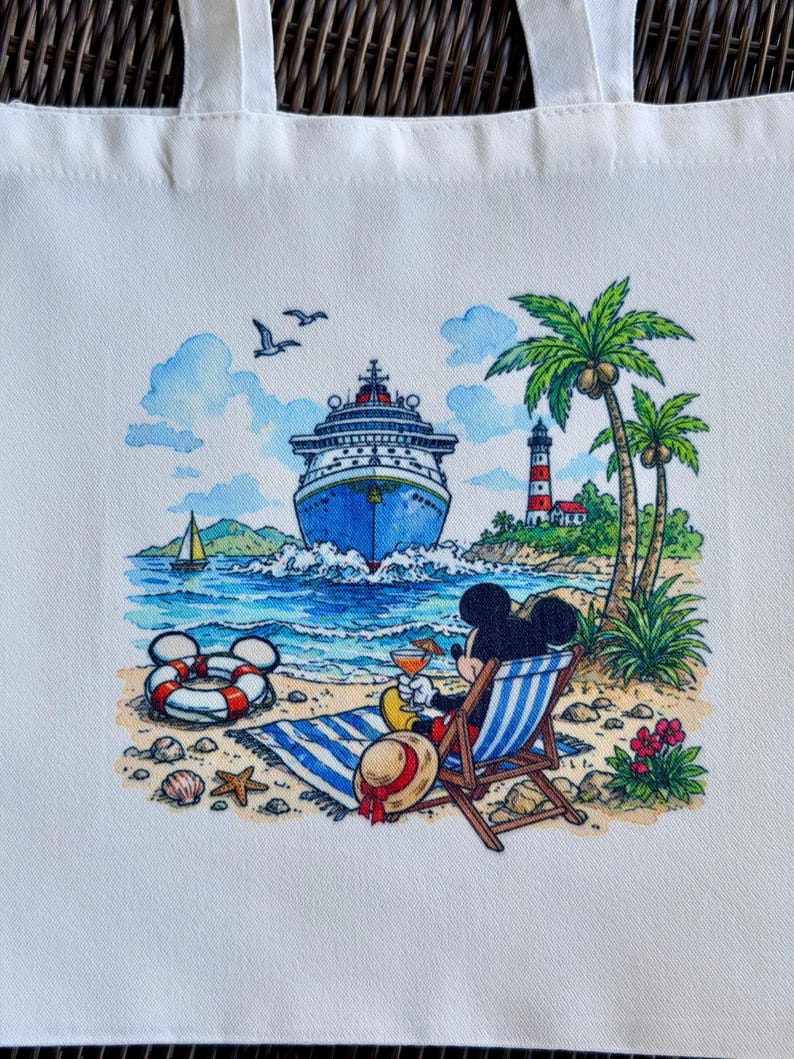 May include: White tote bag featuring a colorful illustration of Mickey Mouse relaxing on a beach. The scene includes a cruise ship, lighthouse, palm trees, and a life preserver. Mickey is in a beach chair with a drink.