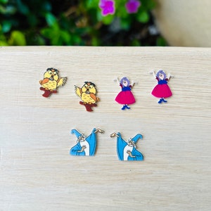 May include: A collection of six colorful character pins. Two owl pins are perched on brown branches. Two pins depict a woman in a pink dress and purple hair. Two pins show a wizard in a blue robe and hat.