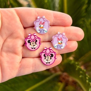 May include: A white ceramic mug with a black handle and the text "But First, Coffee" in a bold, black font. The mug is filled with a dark liquid, likely coffee, and sits on a light-colored surface.