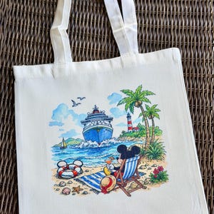 May include: Off-white canvas tote bag featuring a colorful beach scene with a cruise ship, palm trees, and a lighthouse. Mickey Mouse is relaxing in a beach chair. The bag has white handles.