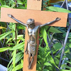 Könnte beinhalten: Ein Holzkruzifix mit einer Jesusfigur aus Metall. Das Kruzifix trägt die Inschrift "INRI" oben.
