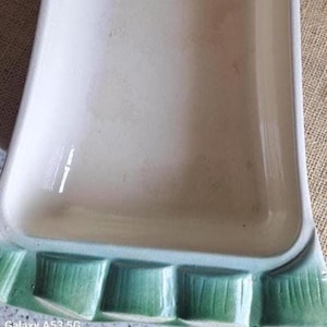 Może przedstawiać: Prostokątny ceramiczny półmisek z gładkim, kremowym wnętrzem oraz teksturowanym, wypukłym brzegiem, który posiada gradient pionowych prostokątnych segmentów w odcieniach od jasnej do ciemnej zieleni na zewnętrznej krawędzi.