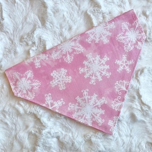 May include: Pink bandana with a white snowflake pattern.