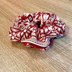 May include: A red and white patterned scrunchie with a snowflake design.