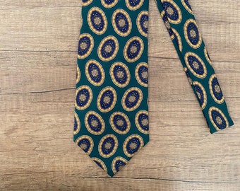 May include: A green silk tie with a repeating pattern of gold and blue oval shapes.