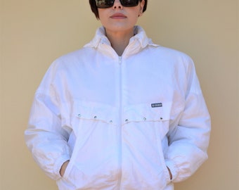 May include: White windbreaker jacket with a zipper closure and a drawstring at the waist. The jacket has a small logo on the left chest that says "GRENOBLE".
