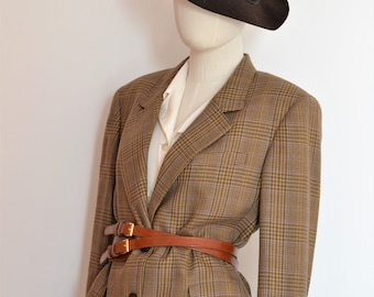 Könnte beinhalten: Ein brauner und beigefarbener karierter Blazer mit einem braunen Ledergürtel. Der Blazer hat einen einzigen Knopfverschluss und einen Schalkragen. Der Gürtel ist zweimal um die Taille gewickelt und hat eine goldene Schnalle.