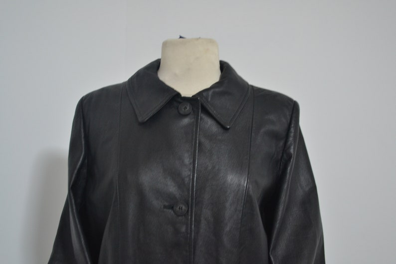 May include: A black leather jacket with a collared neckline and button closure.