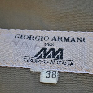May include: White label with black text that reads "Giorgio Armani per AM Gruppo Alitalia" and a size tag that reads "38".