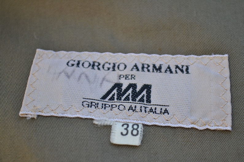 May include: White label with black text that reads "Giorgio Armani per AM Gruppo Alitalia" and a size tag that reads "38".