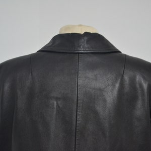 May include: Black leather jacket with a classic collar and a single-breasted closure. The jacket has a smooth, polished finish.