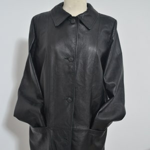 May include: A black leather jacket with a button-up front and two pockets. The jacket has a collar and long sleeves.