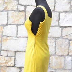 May include: A sleeveless yellow dress with a zipper down the back.