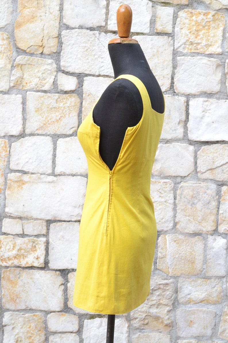 May include: A sleeveless yellow dress with a zipper down the back.