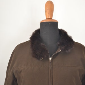 K&ouml;nnte beinhalten: Eine braune Jacke mit Rei&szlig;verschluss und einem braunen Pelzkragen.