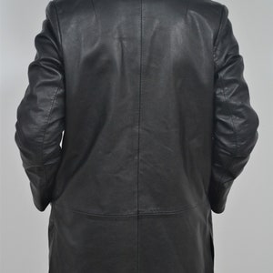 May include: A black leather jacket with a long, fitted style. The jacket has a classic collar and a single-breasted closure.